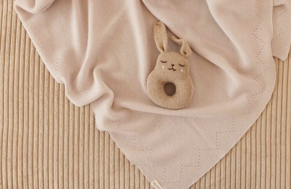Leichte, gestrickte Babydecke mit Lochmuster aus weicher Merinowolle ideal zum Einpucken.
